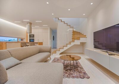 Maison moderne équipée d’un écran géant, d’un escalier design, salon stylé avec décoration et carrelage